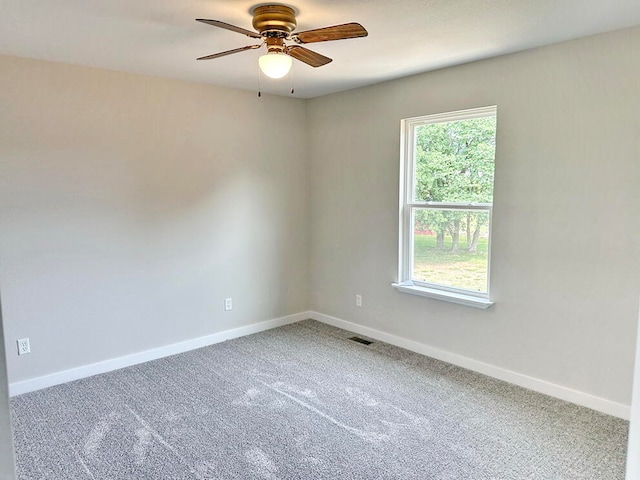 carpeted empty room featuring ceiling fan and a healthy amount of sunlight