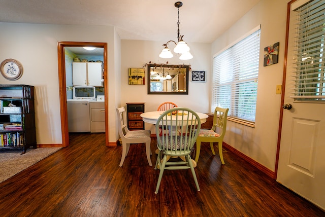 dining area with a notable chandelier, washer and clothes dryer, and dark hardwood / wood-style flooring