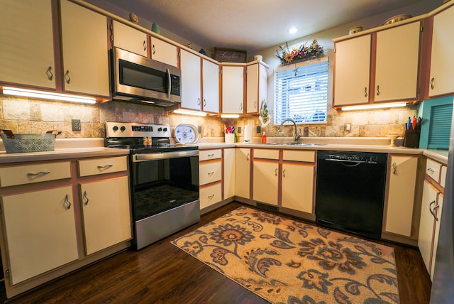 kitchen with sink, appliances with stainless steel finishes, dark wood-type flooring, and backsplash