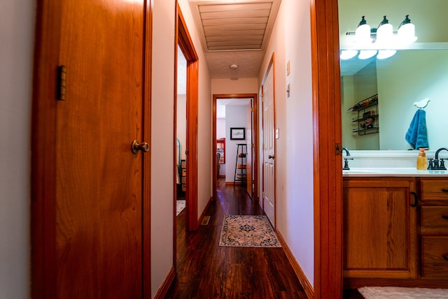 corridor with dark hardwood / wood-style floors and sink