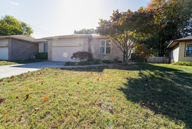 single story home with a front yard, central AC, and a garage