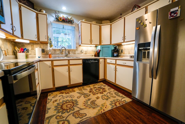 kitchen with sink, white cabinetry, stainless steel appliances, dark wood-type flooring, and decorative backsplash