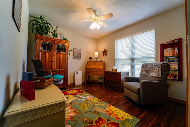 sitting room with a textured ceiling, dark hardwood / wood-style floors, and ceiling fan