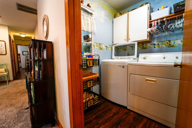 washroom with cabinets, independent washer and dryer, and dark hardwood / wood-style flooring