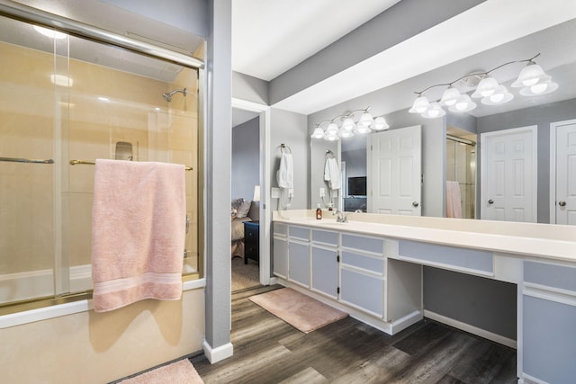 bathroom featuring vanity, bath / shower combo with glass door, and hardwood / wood-style flooring