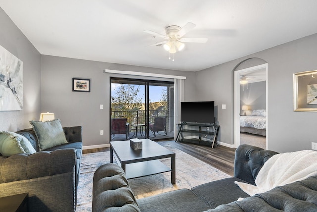 living room with dark wood-type flooring and ceiling fan