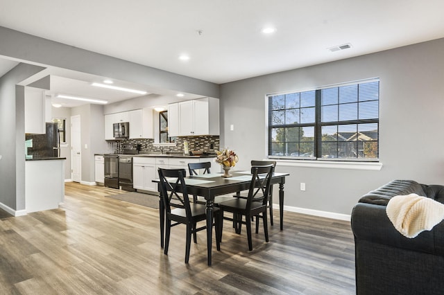 dining space with wood-type flooring