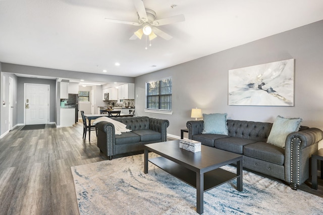 living room featuring wood-type flooring and ceiling fan