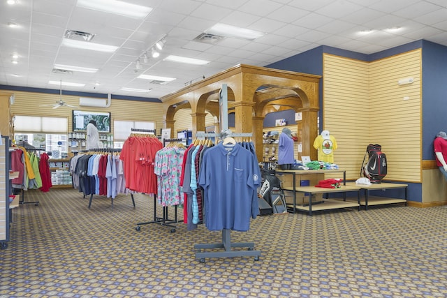 interior space with carpet, a paneled ceiling, and ceiling fan