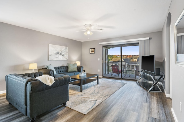 living room with ceiling fan and dark hardwood / wood-style flooring