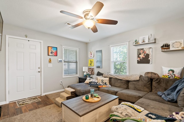 living room with dark wood-type flooring and ceiling fan