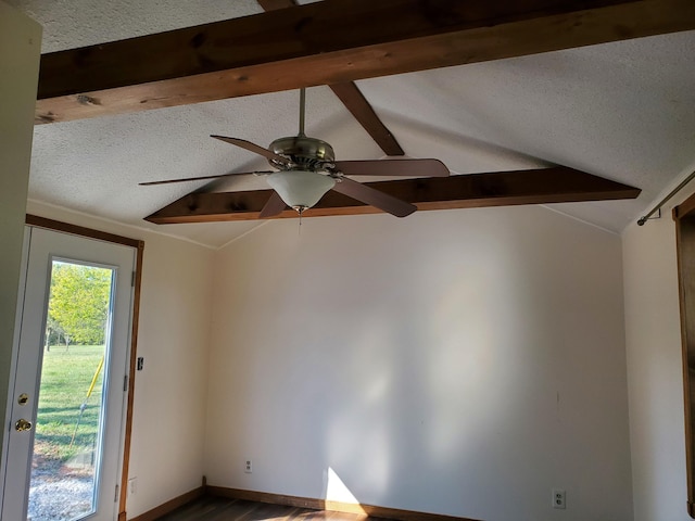 spare room featuring a textured ceiling, lofted ceiling with beams, and ceiling fan