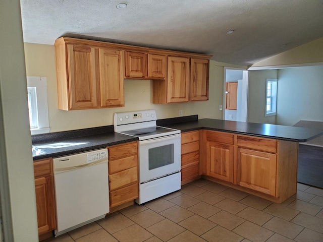 kitchen with white appliances, a textured ceiling, kitchen peninsula, vaulted ceiling, and light tile patterned floors