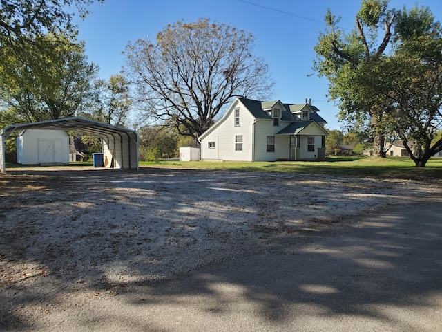 view of side of home with a storage shed, a lawn, and a carport