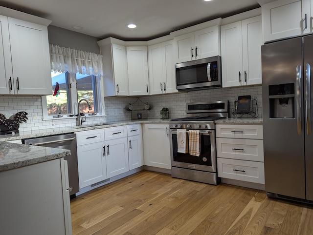 kitchen featuring stainless steel appliances, white cabinetry, and sink