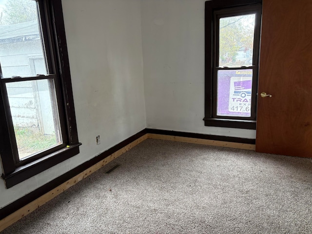 unfurnished room featuring carpet floors and a healthy amount of sunlight