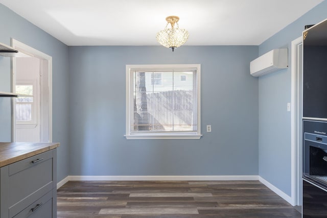 unfurnished dining area with a wall mounted air conditioner and dark hardwood / wood-style floors