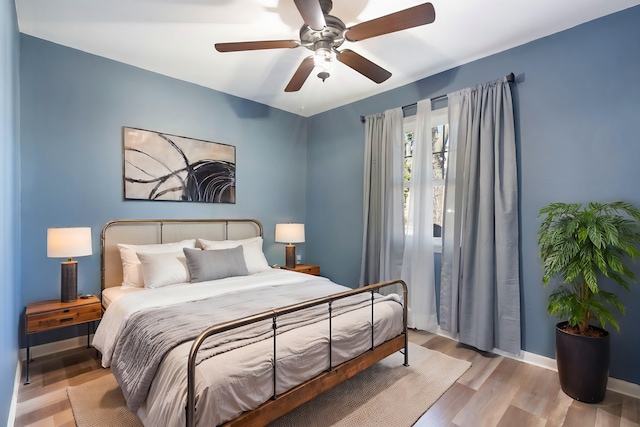 bedroom with light hardwood / wood-style flooring and ceiling fan