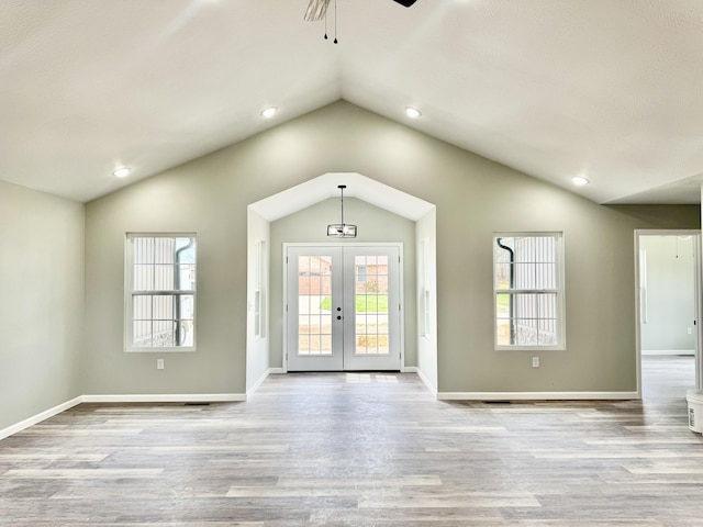 interior space with lofted ceiling, french doors, baseboards, a ceiling fan, and wood finished floors