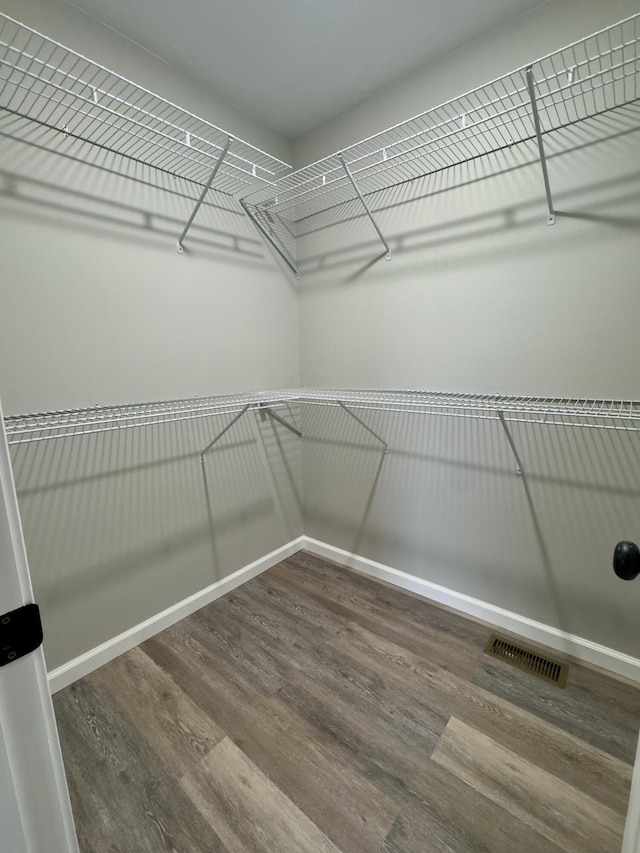 spacious closet featuring visible vents and wood finished floors