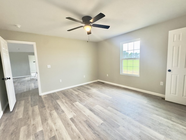 unfurnished bedroom featuring baseboards, wood finished floors, and a ceiling fan