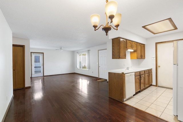 kitchen featuring sink, a textured ceiling, white appliances, ceiling fan with notable chandelier, and light wood-type flooring