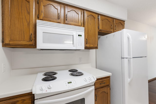 kitchen with hardwood / wood-style floors and white appliances