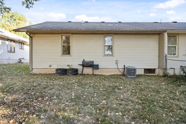 back of property with a lawn and cooling unit