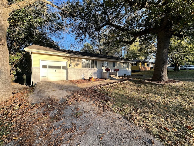 ranch-style home with a garage and a front lawn