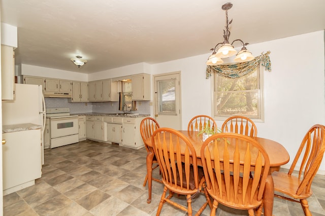 dining space featuring a chandelier and sink