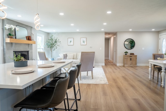 dining room featuring light hardwood / wood-style flooring and a large fireplace