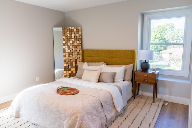 bedroom featuring multiple windows and light wood-type flooring