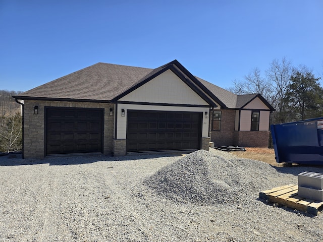 ranch-style house with gravel driveway, an attached garage, and a shingled roof