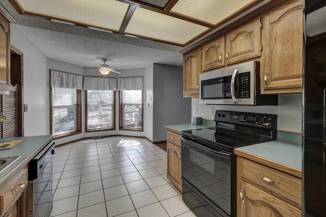 kitchen featuring a textured ceiling, light tile patterned flooring, stainless steel appliances, and ceiling fan