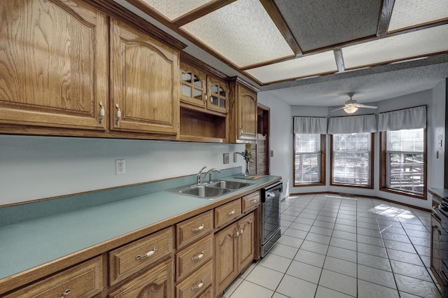 kitchen with light tile patterned floors, ceiling fan, a textured ceiling, stainless steel dishwasher, and sink