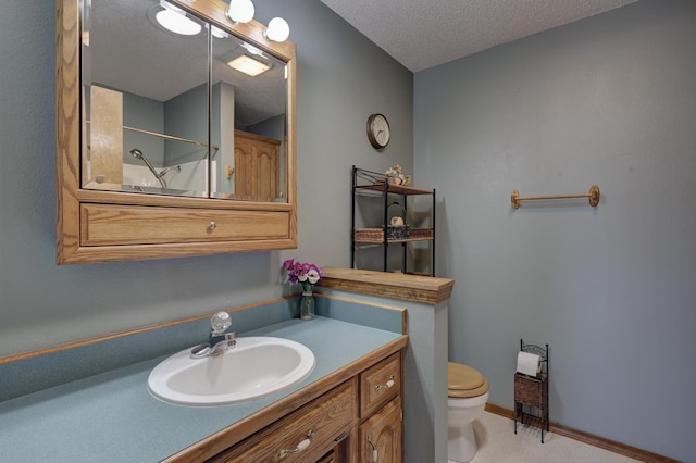 bathroom with toilet, a textured ceiling, walk in shower, and vanity