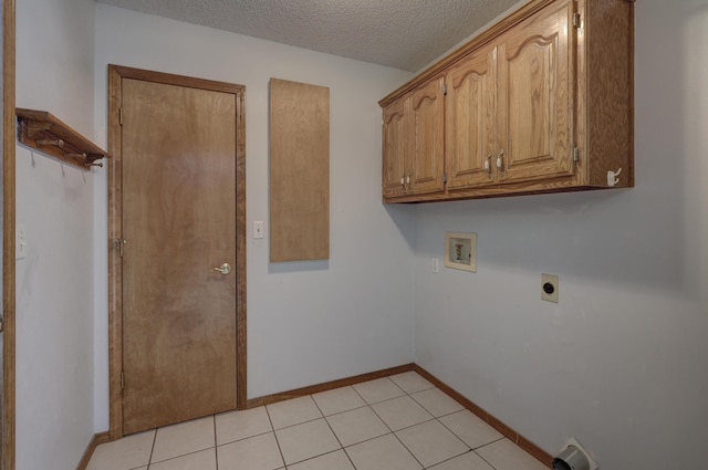 clothes washing area with washer hookup, hookup for an electric dryer, light tile patterned floors, a textured ceiling, and cabinets