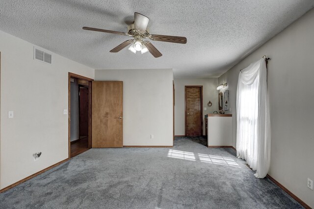 unfurnished room with a textured ceiling, light colored carpet, and ceiling fan