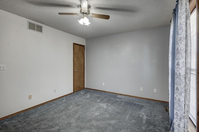 spare room with dark carpet, a textured ceiling, and ceiling fan