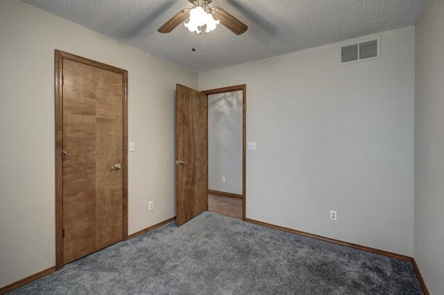 unfurnished bedroom featuring a textured ceiling, light colored carpet, and ceiling fan