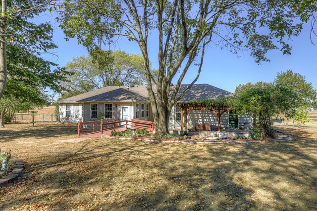 rear view of house with a deck and a lawn