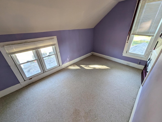 bonus room featuring carpet flooring, vaulted ceiling, and plenty of natural light