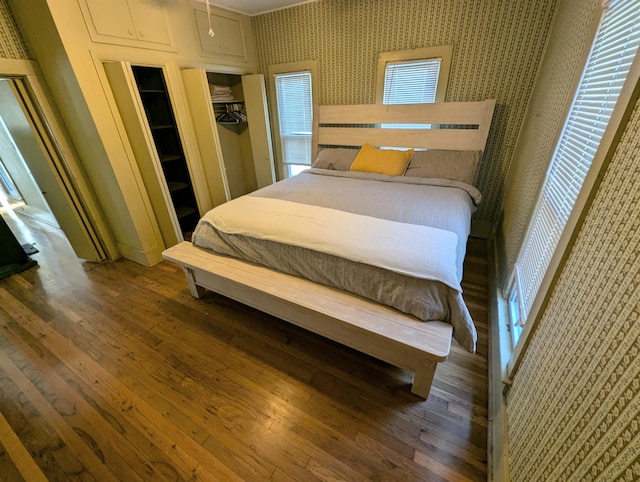 bedroom with dark wood-type flooring and a closet