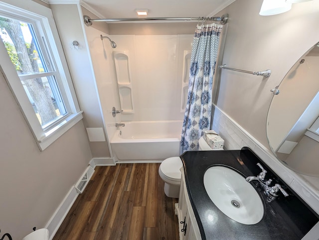 full bathroom featuring wood-type flooring, toilet, shower / bath combo with shower curtain, vanity, and ornamental molding