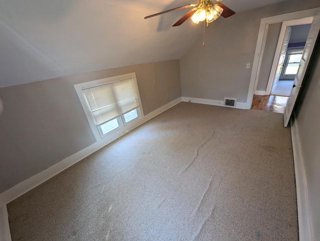 bonus room featuring lofted ceiling, carpet, and ceiling fan