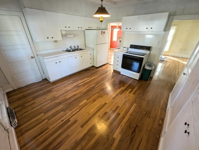 kitchen featuring dark wood-type flooring, hanging light fixtures, sink, white cabinets, and white appliances