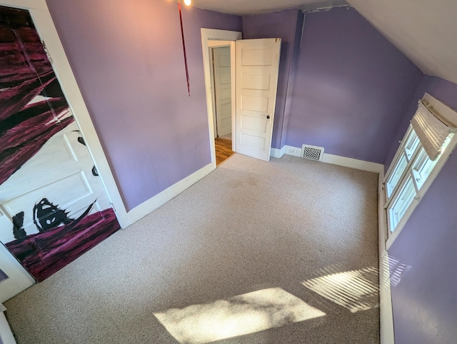 additional living space featuring lofted ceiling and carpet