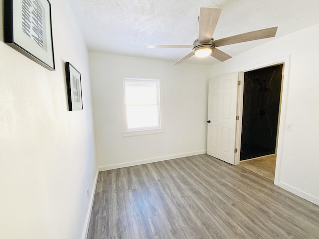 unfurnished room featuring ceiling fan, a textured ceiling, and light wood-type flooring