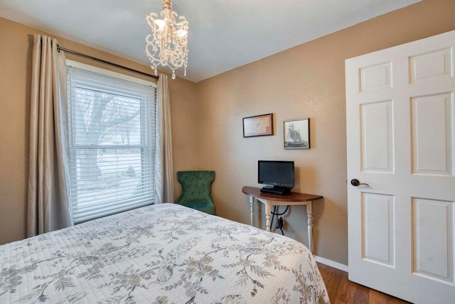 bedroom featuring a notable chandelier and dark hardwood / wood-style flooring