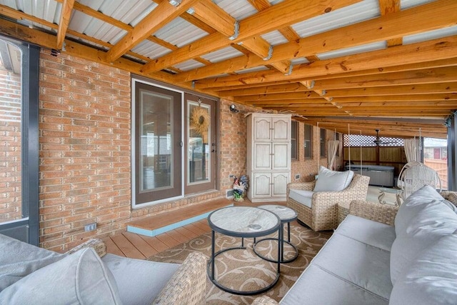 living room with beam ceiling, wood-type flooring, and brick wall